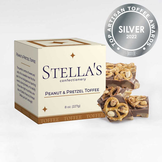 Box of Peanut and Pretzel toffee next to toffee pieces and a silver award badge
