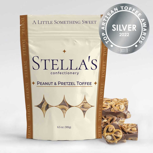 Stand up pouch of Peanut and Pretzel toffee next to toffee pieces and a silver award badge